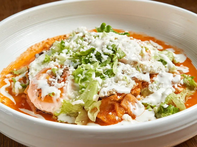 Imagen de referencia: chilaquiles rojos con lechuga, queso y crema