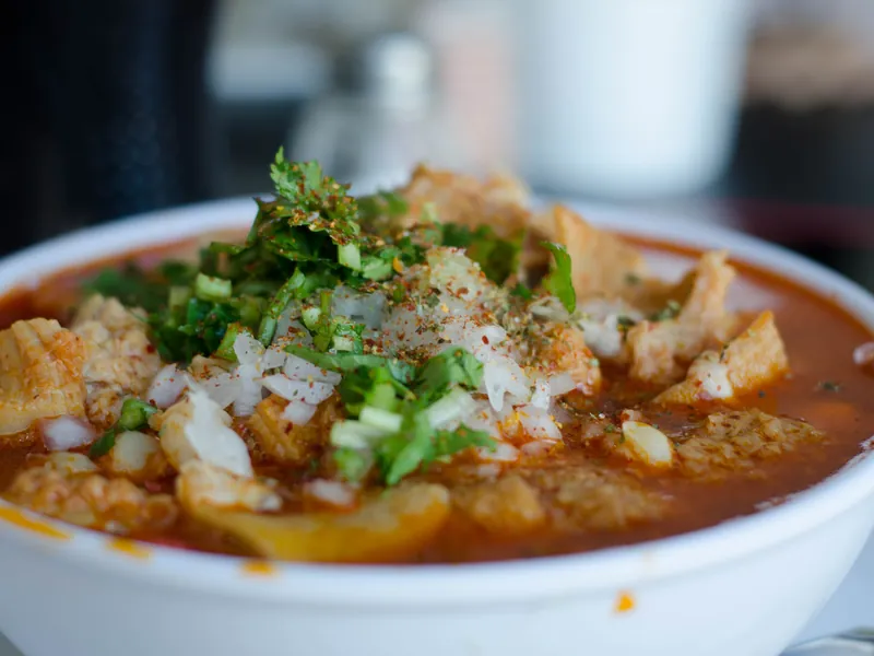 Imagen de referencia: plato hondo de pancita en caldo rojo con cebolla y cilantro